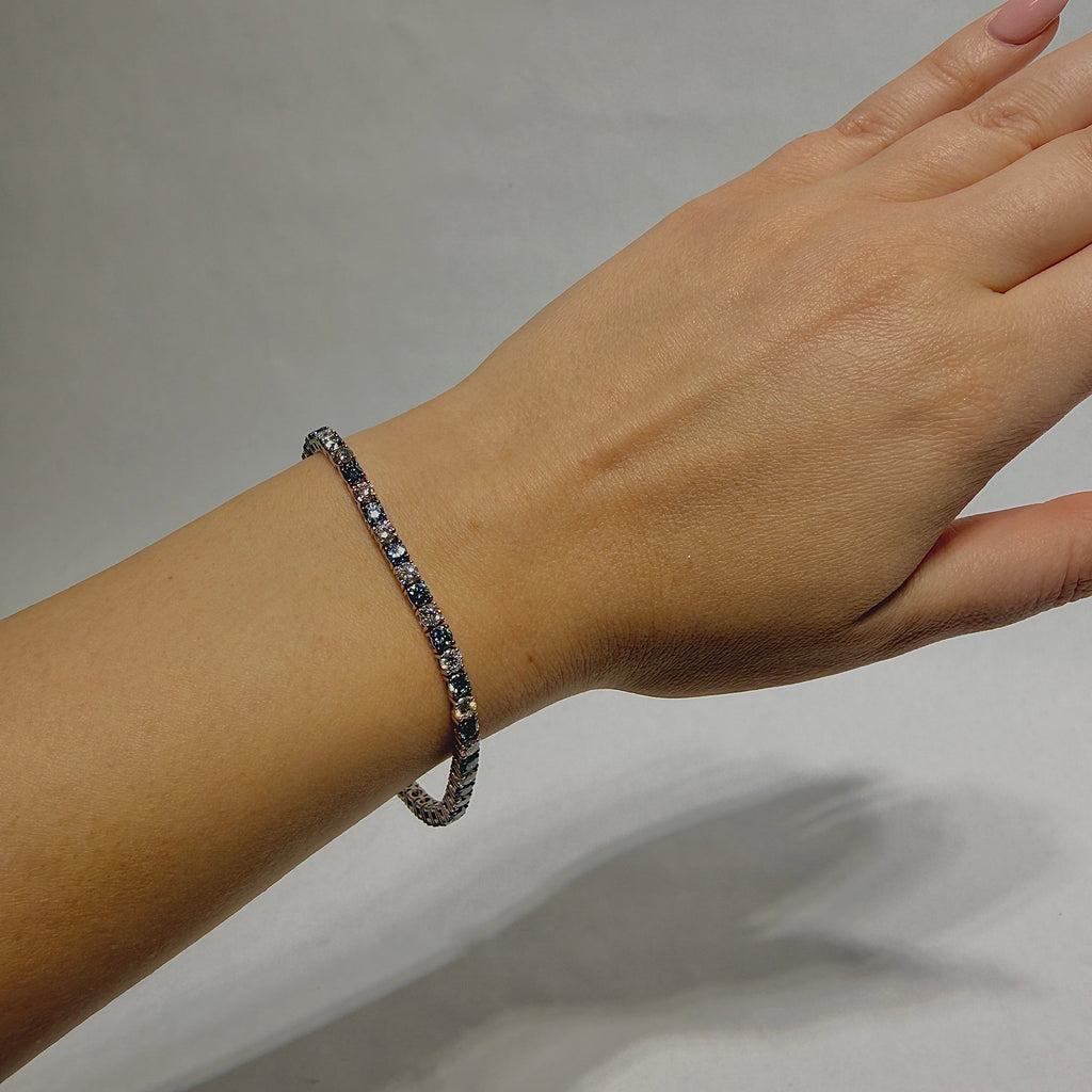 Hand wearing a bracelet on a plain background